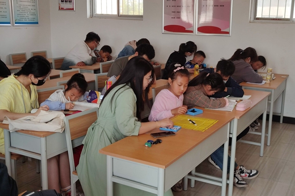 6d76e94569144b9e89f2e353cf651b17.jpg 志愿者为孩子辅导作业.jpg