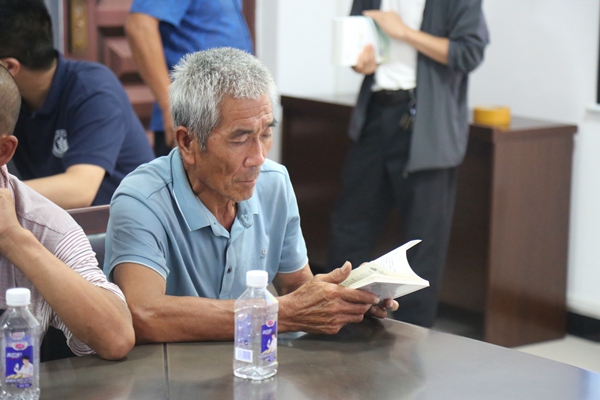 3f4bb6d6528d439da9724218211d0622.jpg 养殖户翻看湖羊养殖技术手册.jpg